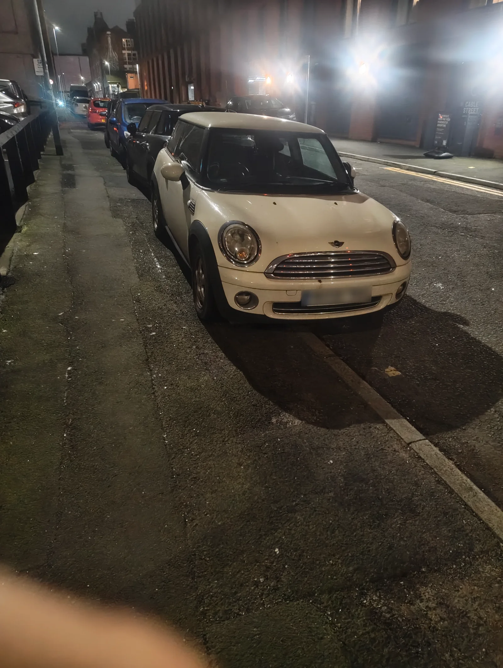 Cream MINI R56 parked on a city street at night
