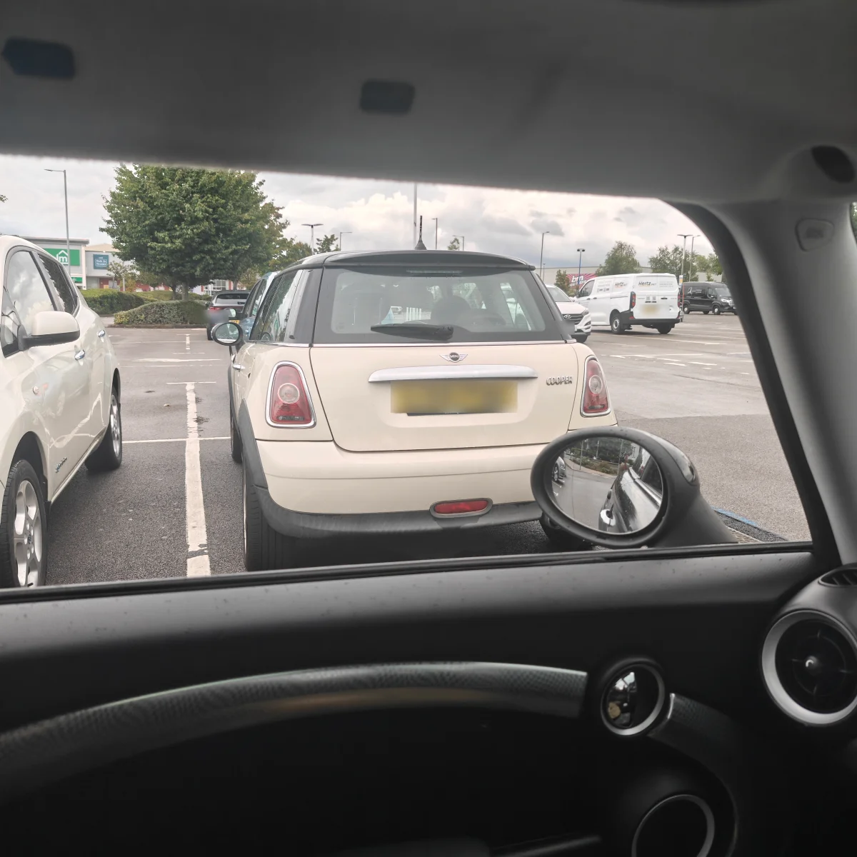 Cream MINI R56 in a rainy car park