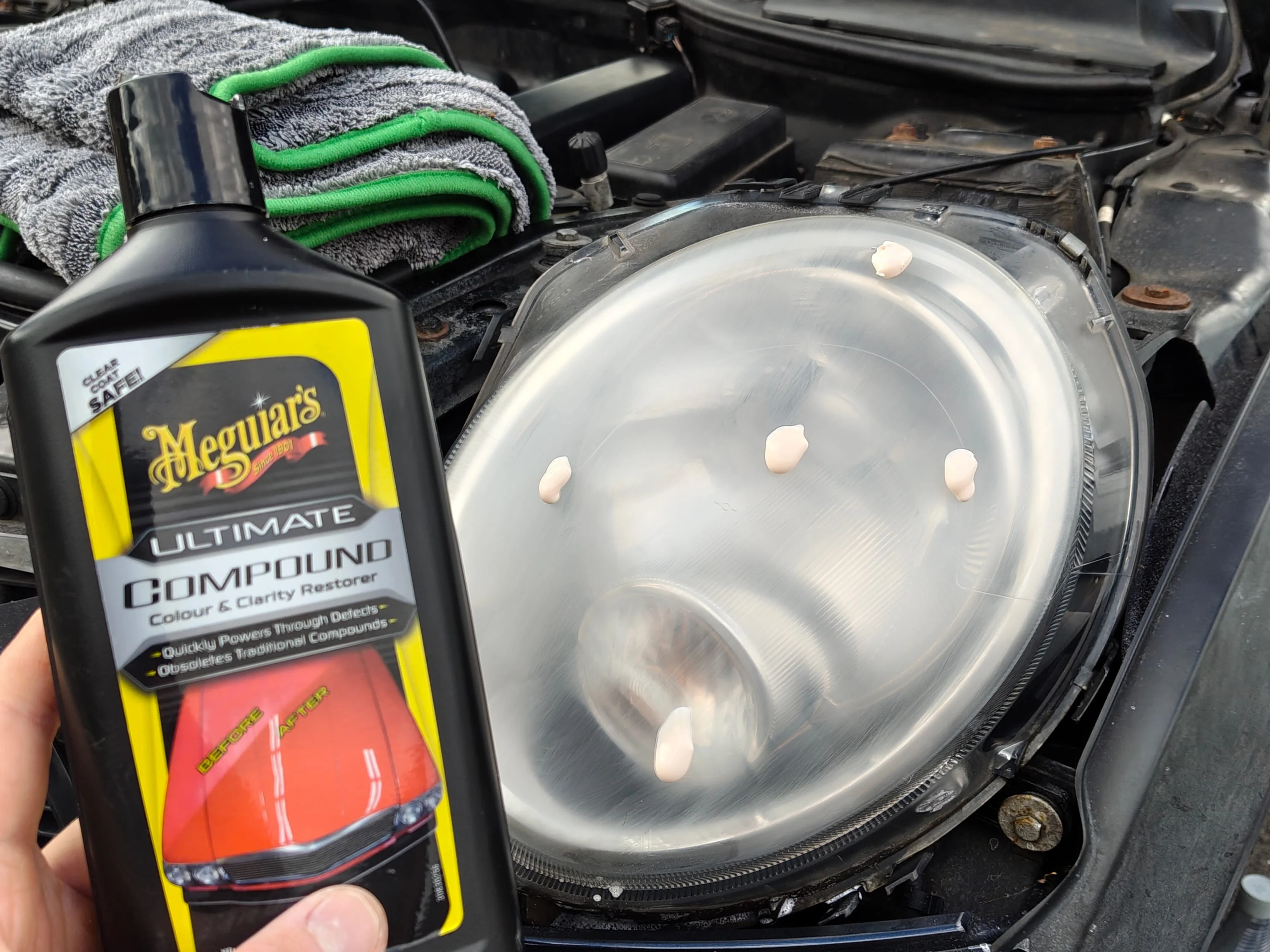 Dots of Meguiar's Ultimate Compound on a headlight