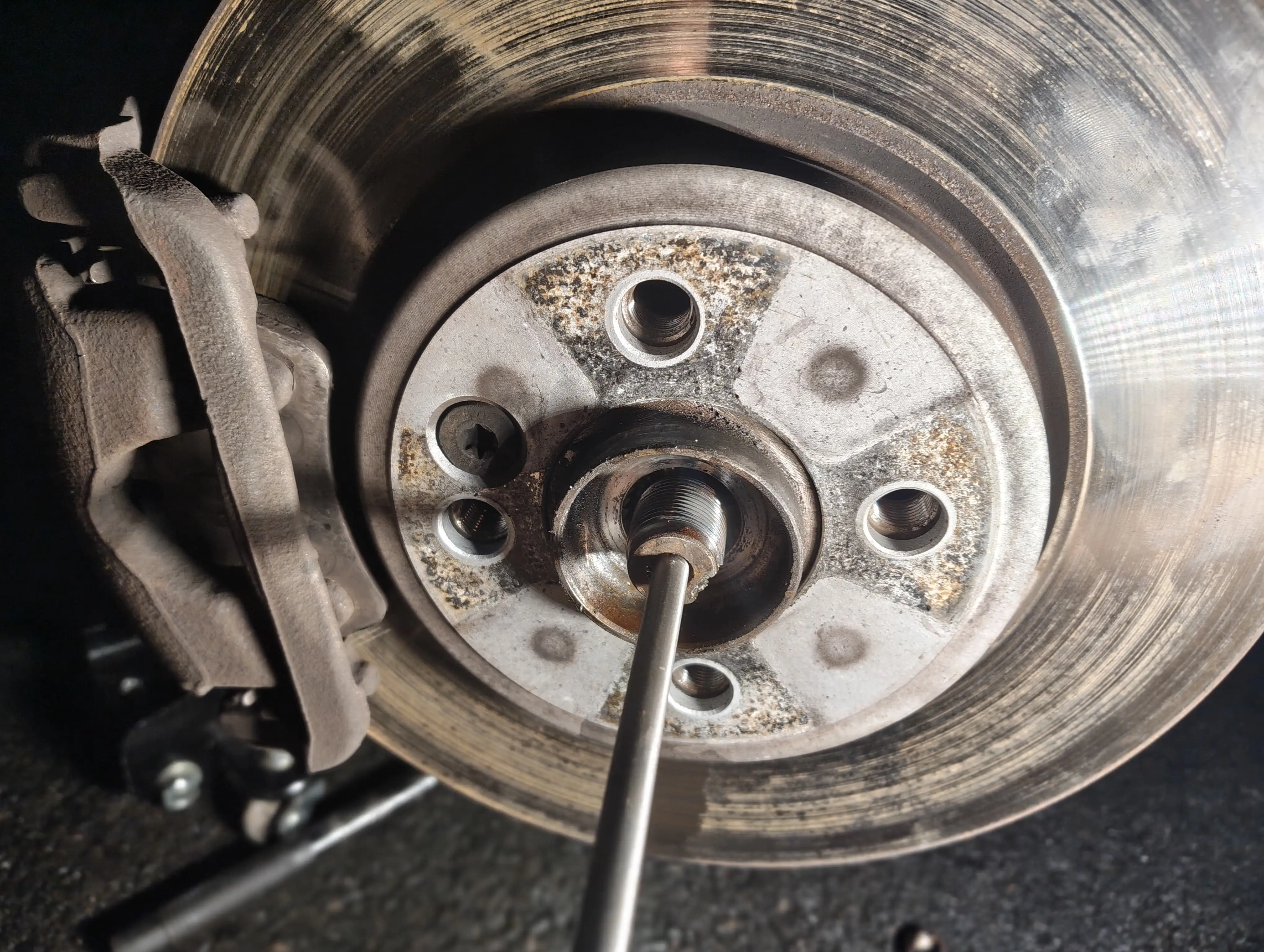 Hammering the front passenger-side driveshaft spline with a club hammer and punch