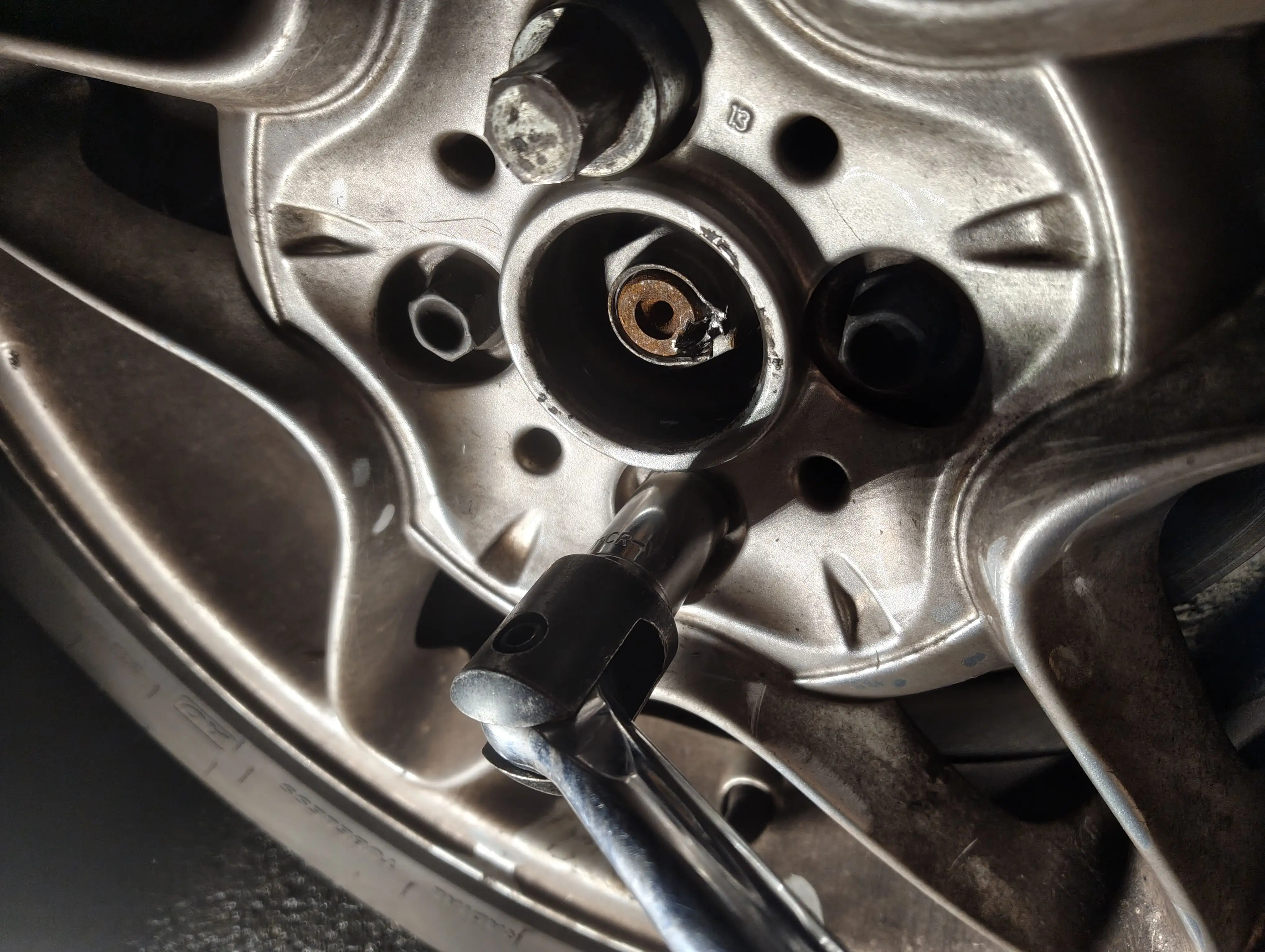 Loosening the front passenger-side lug nuts with a breaker bar