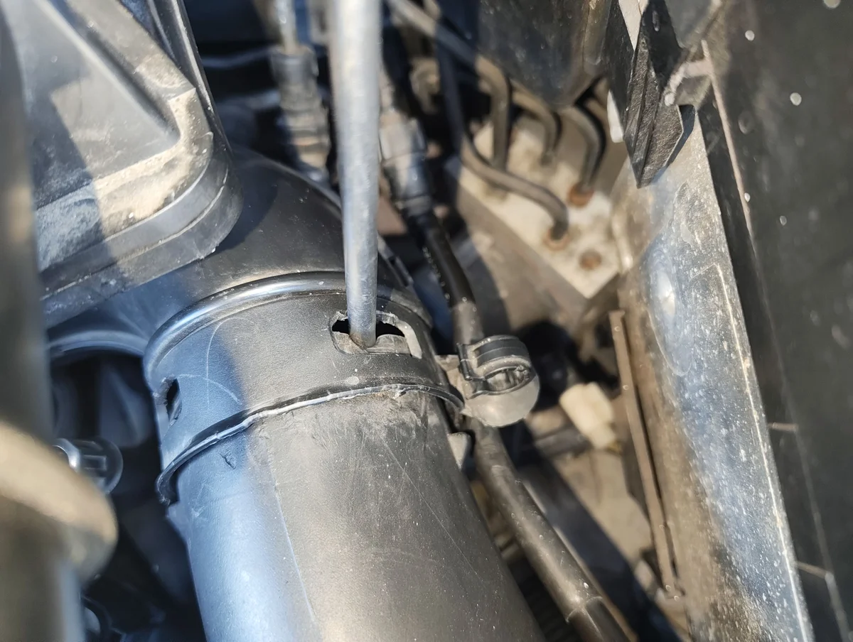 Pressing right side air intake clip in with a flathead screwdriver