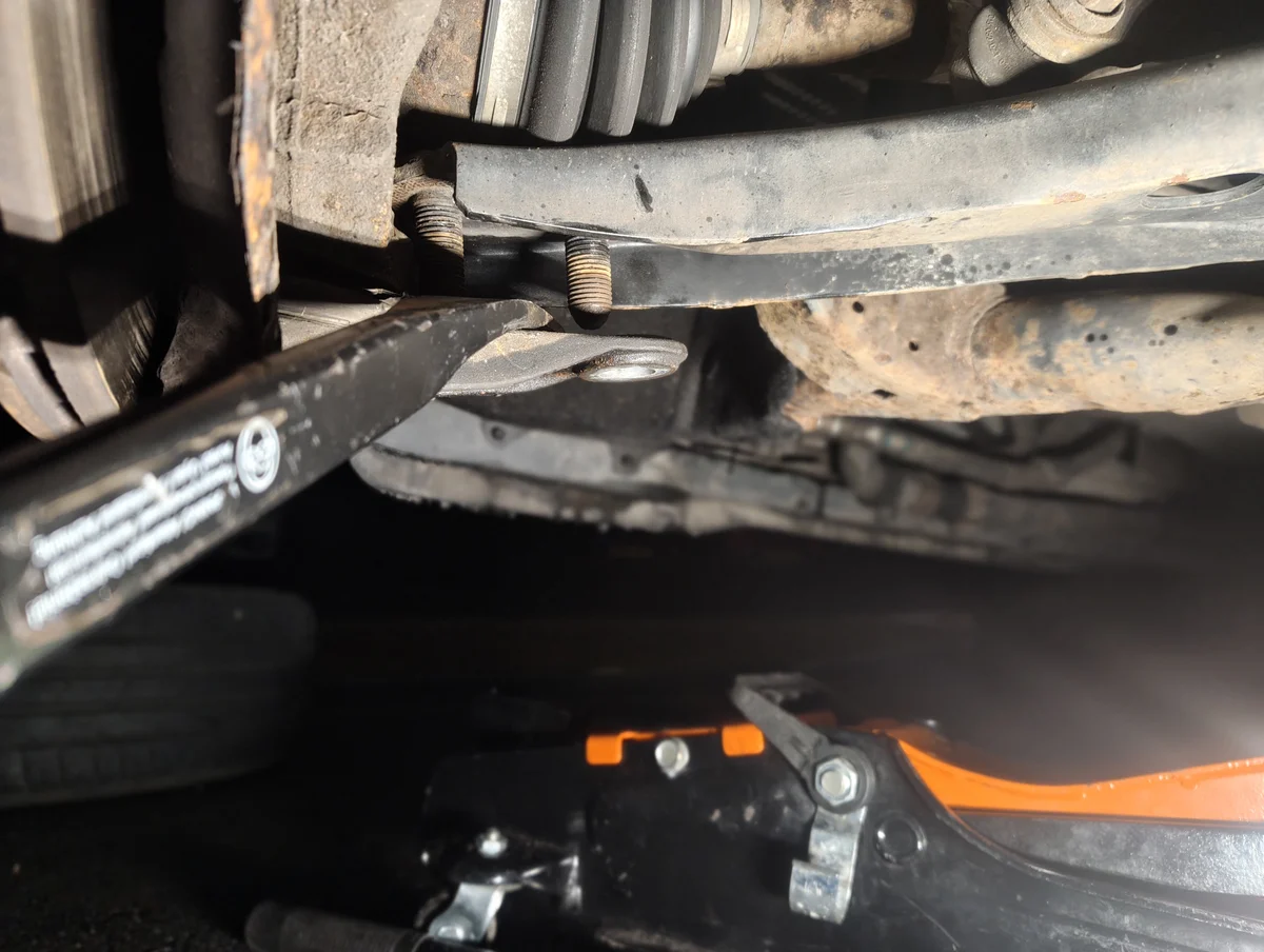 Prying the front passenger-side lower ball joint bracket from the lower suspension arm
