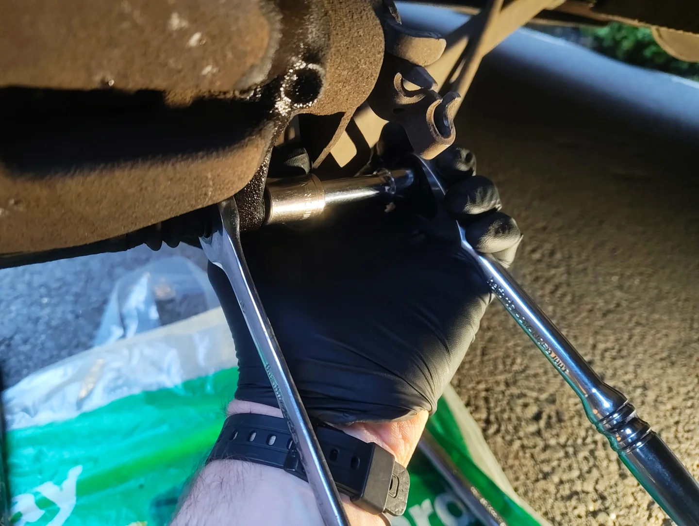 Ratchet and spanner on brake caliper bottom bolt