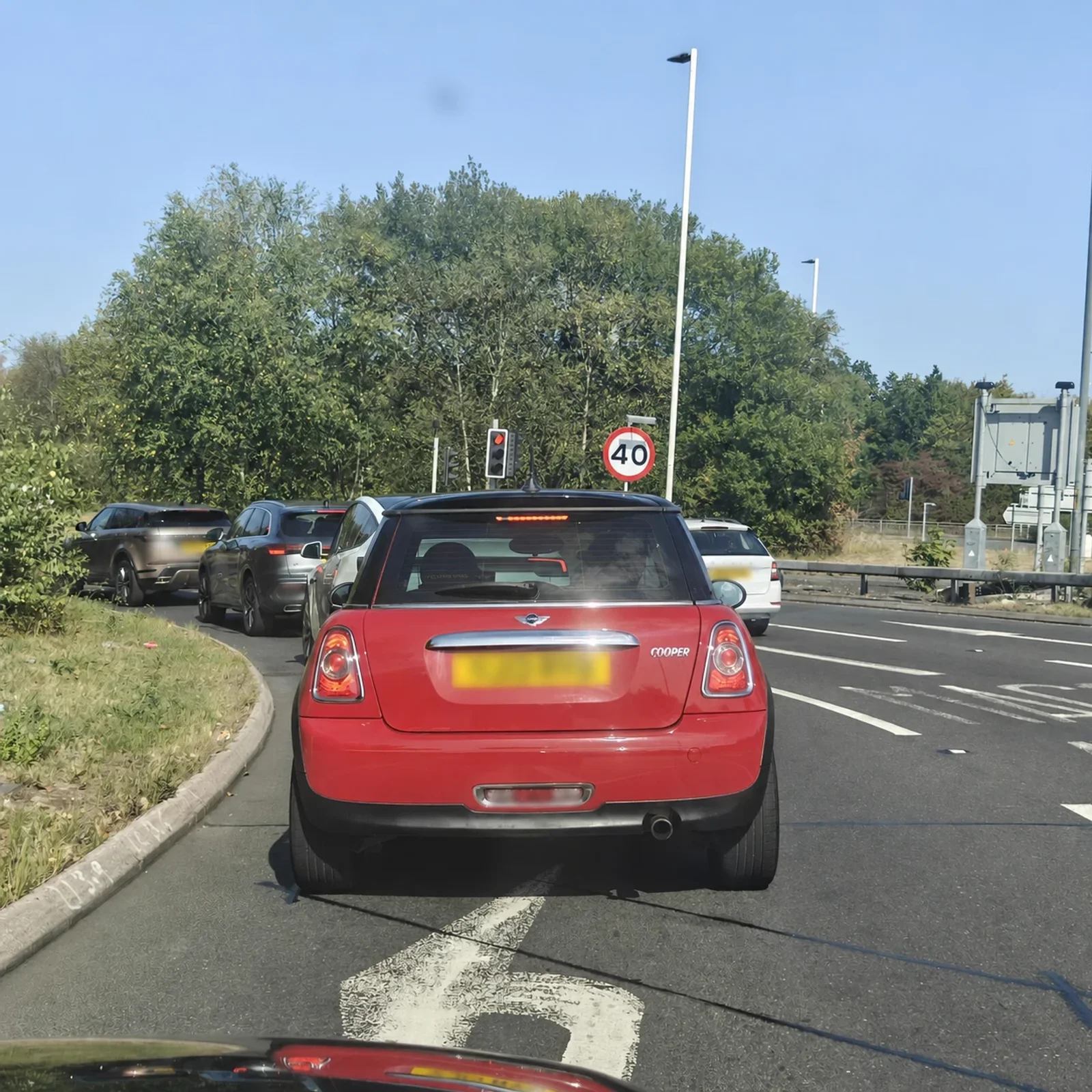 Red MINI R56 waiting in daytime traffic