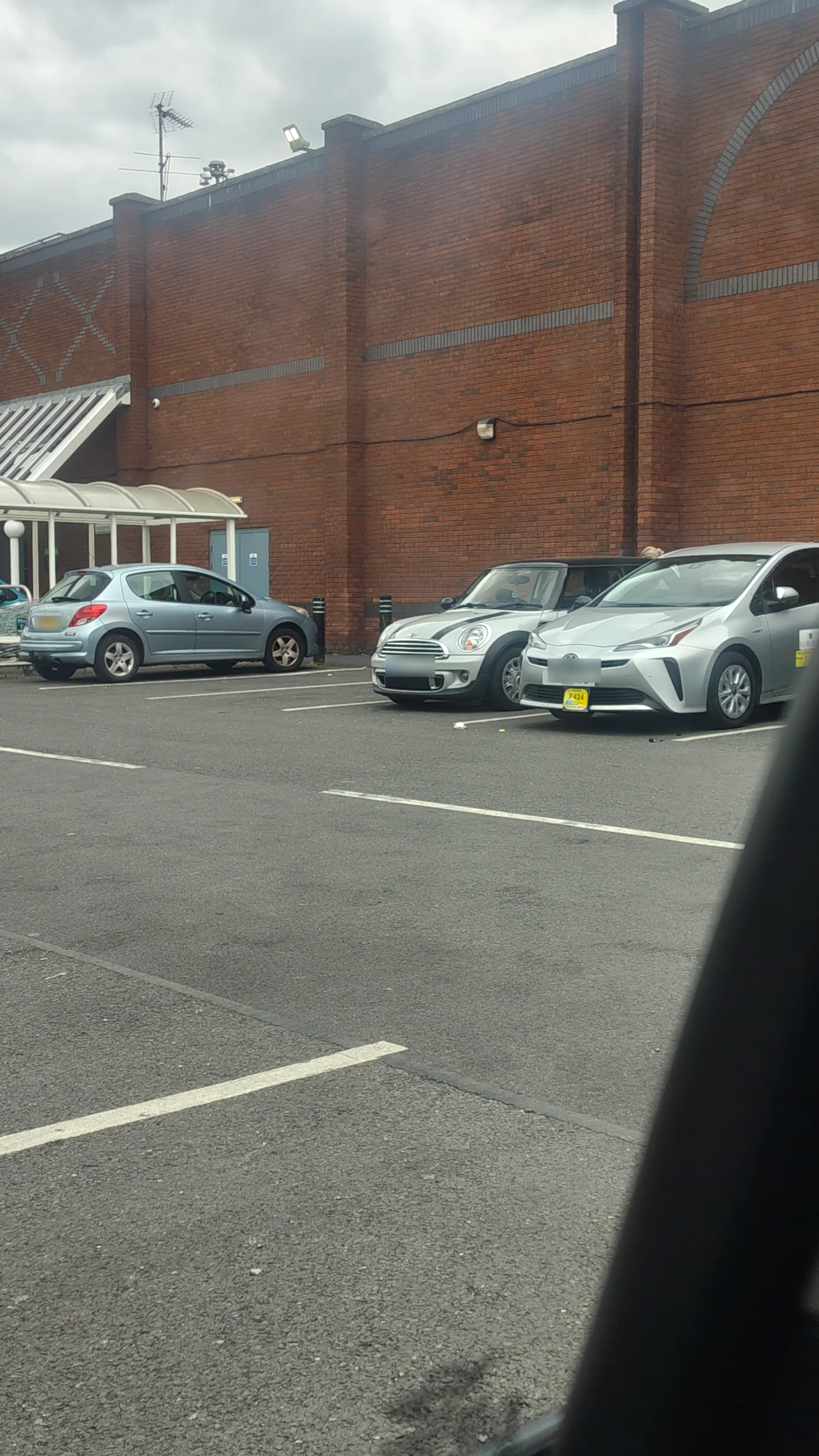 Silver MINI R56 parked outside a brick building
