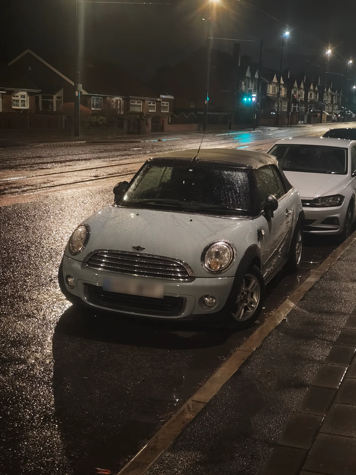 Silver MINI R56 parked on a rainy street at night
