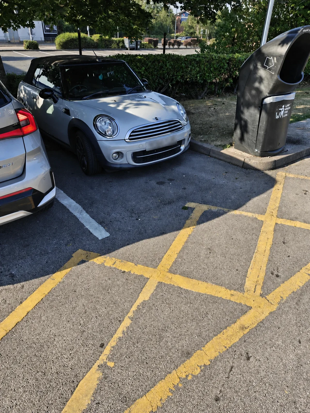 Silver MINI R56 parked beneath leafy trees