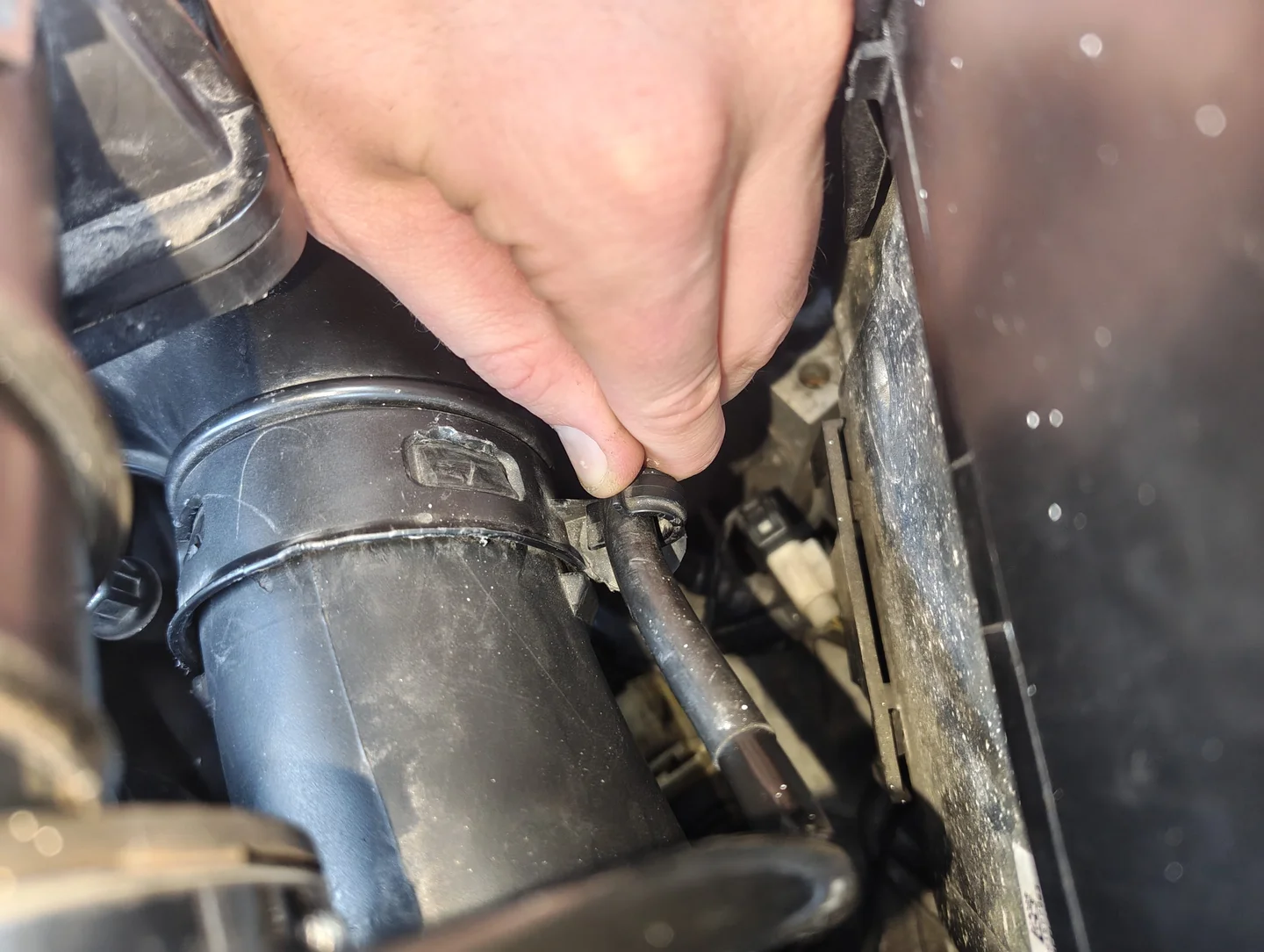 Uncliping vacuum line from air intake duct