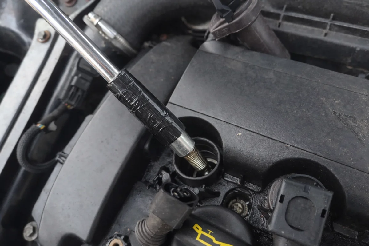 Unscrewed spark plug inside spark plug socket
