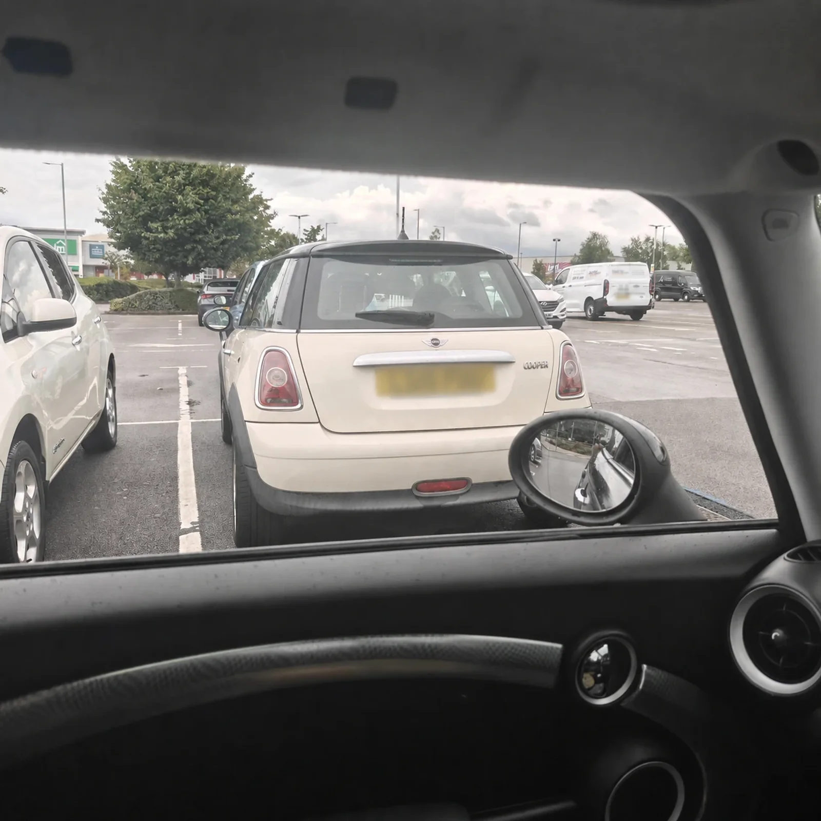 White MINI R56 in a rainy car park