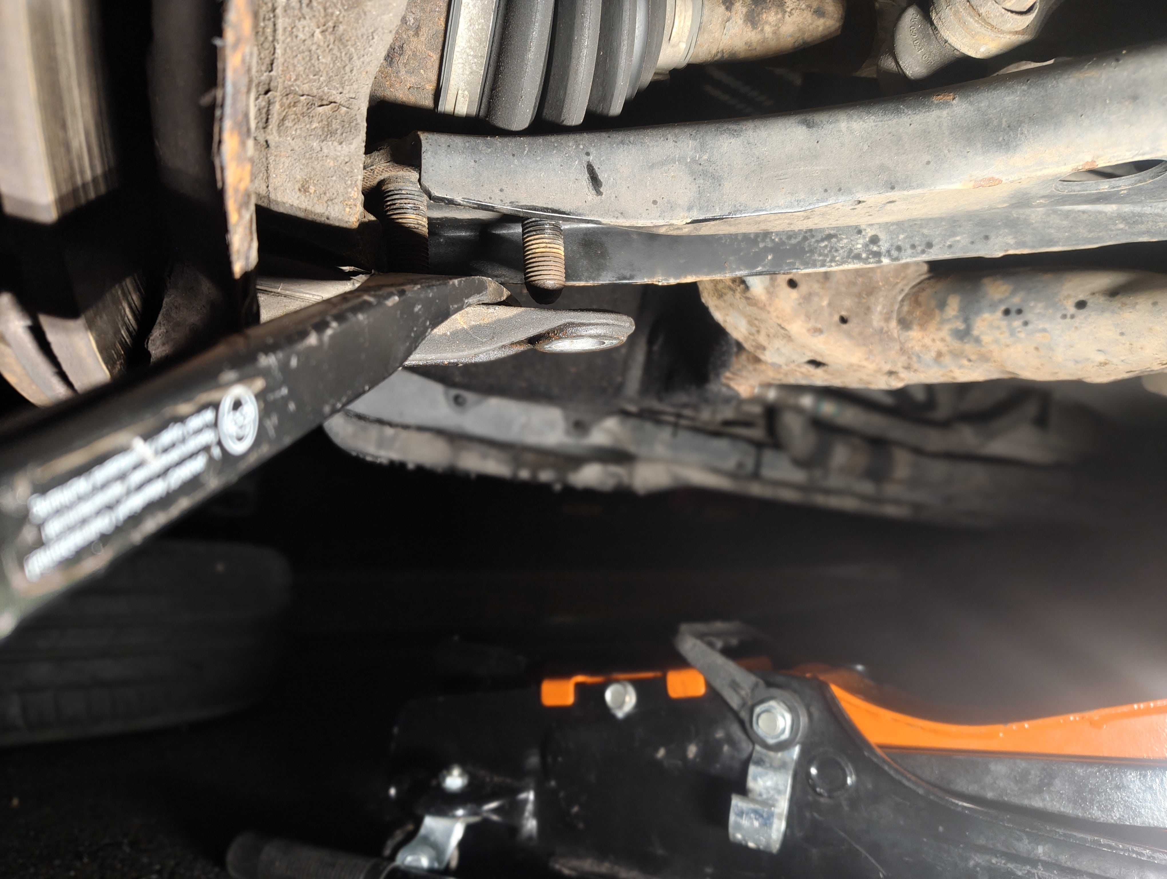 Prying the front passenger-side lower ball joint bracket from the lower suspension arm